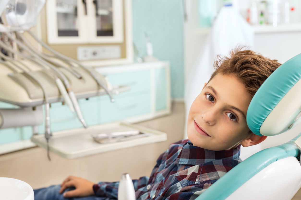 Cute boy in orthodontic office smiling