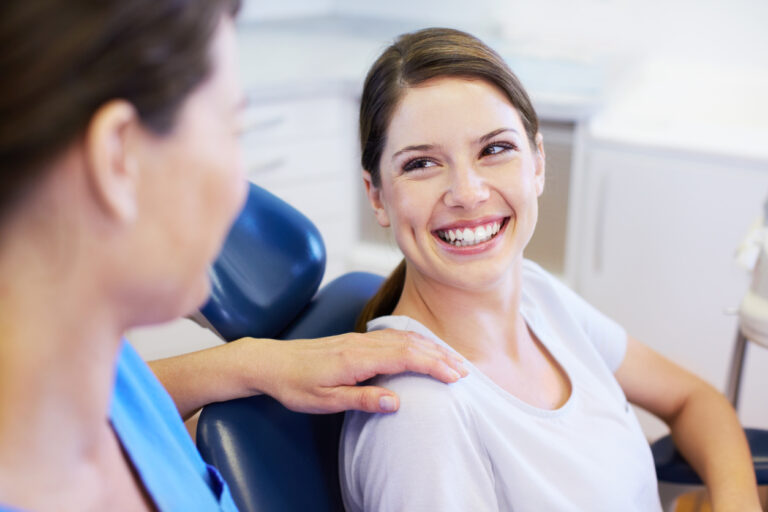 A pretty young woman having a conversation with her friendly orthodontist