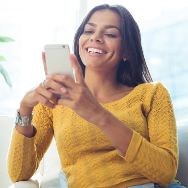 smiling woman looking at phone